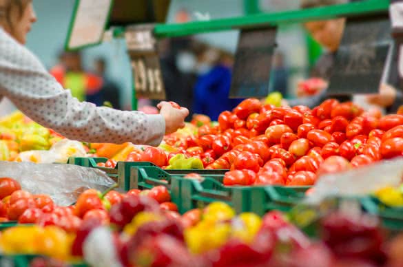 Customers selecting tomatoes in supermarket