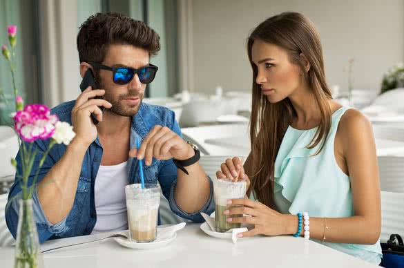 Handsome man with beautiful woman in cafe talking by the smart phone