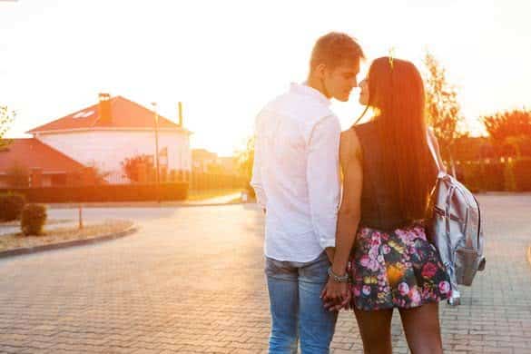 Couple in love kissing laughing having fun and walking on the evening street