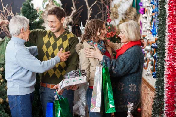 Happy family with shopping bags and presents embracing each other in Christmas store