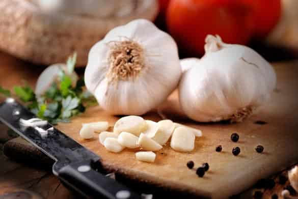 sliced garlic on wooden chopping board