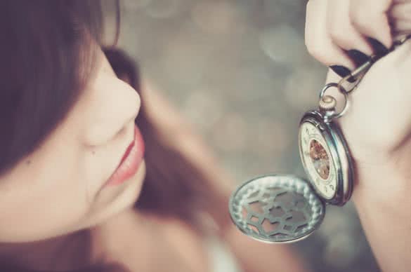 young woman checking time on a pocket watch