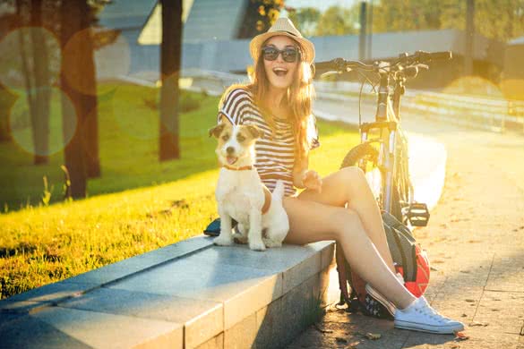 Happy Hipster Girl with her Dog and Bike in the City
