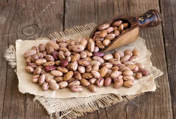 Pinto beans with a spoon on a wooden table