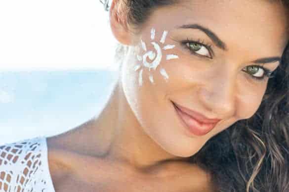 Carefree Young Woman With Suncream On Face At Beach