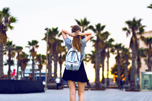 Outdoor lifestyle fashion portrait of young hipster woman walking at Barcelona