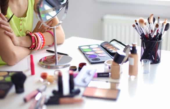 Young beautiful woman making make-up near mirror