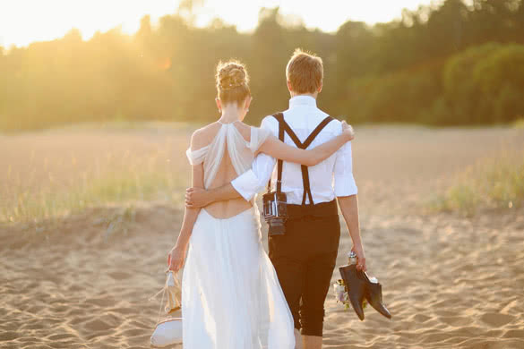 Happy bride and groom on a beautiful beach on sunset