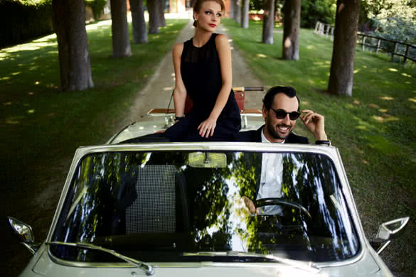 Happy couple enjoying a ride on their luxury convertible in the summer