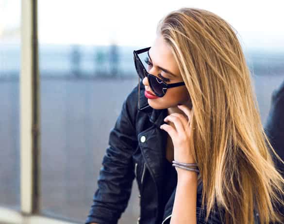 Stylish lady in black posing near mirrored wall