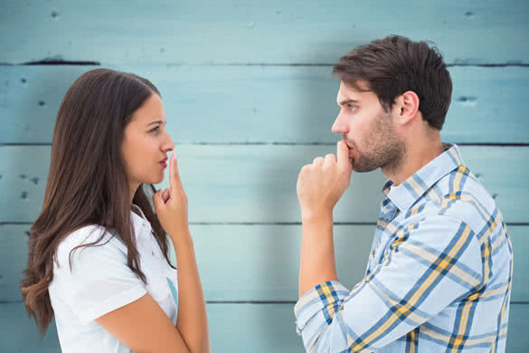 Upset young couple not talking against painted blue wooden planks