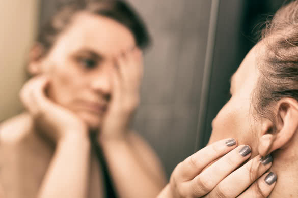 Mirror reflection of depressed woman