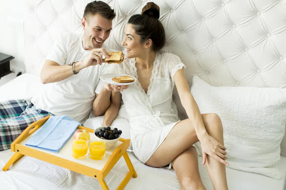 Young couple having a breakfast in the bed