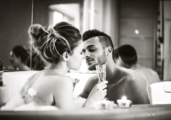 Young happy couple enjoying bath in the jacuzzi