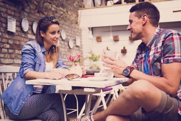 Young happy couple sitting at cafe