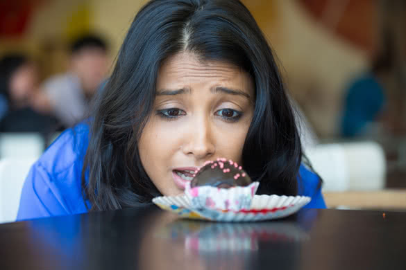 desperate woman in blue shirt craving fudge with pink sprinkles dessert