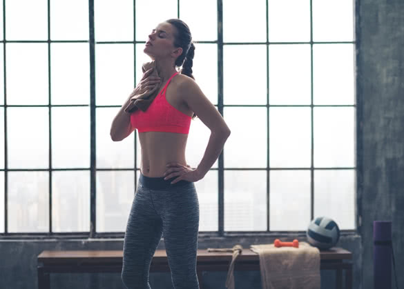 A woman wipes hard-earned sweat off her neck after a great workout