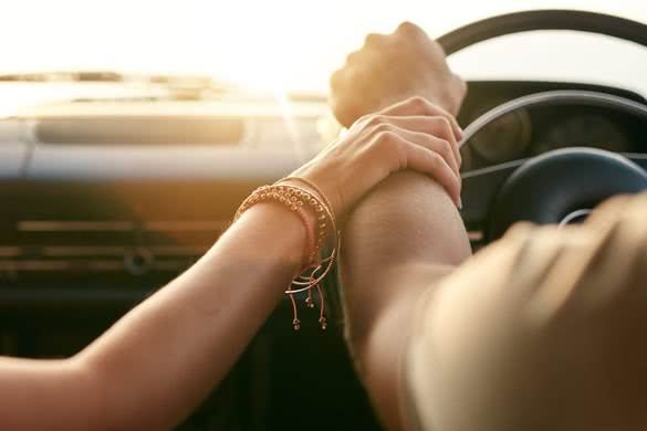 Close up shot of loving couple traveling by car and holding hands