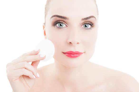 Skincare concept with woman using cotton face cleaner disc