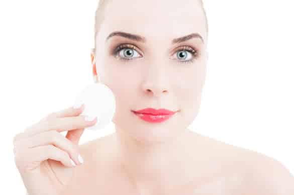 Skincare concept with woman using cotton face cleaner disc