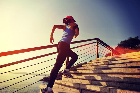 healthy lifestyle sports woman running up on stone stairs sunrise seaside