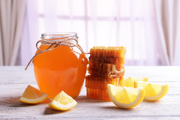 Delicious honey with lemon on table