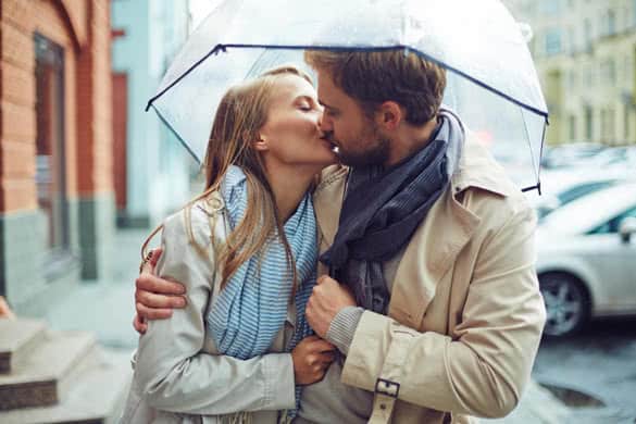 Loving young couple in love under umbrella in the rain