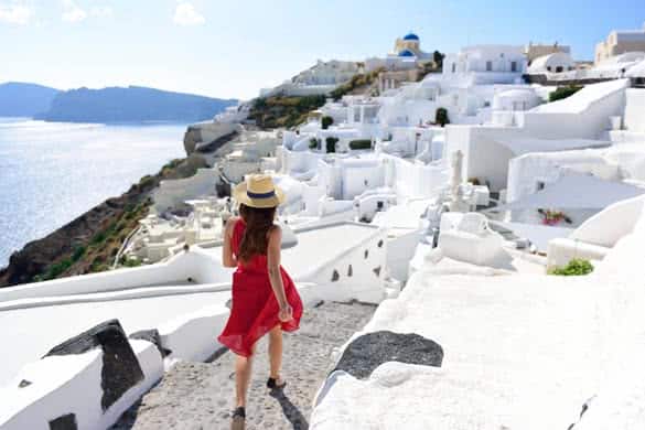 Santorini travel tourist woman on vacation in Oia walking on stairs