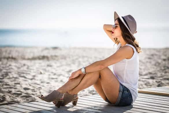 Stylish woman at the summer beach in a hot day