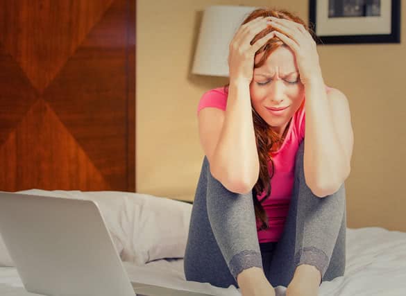 portrait stressed sad young woman sitting on bed looking desperate