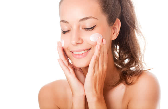 woman putting on moisturizer