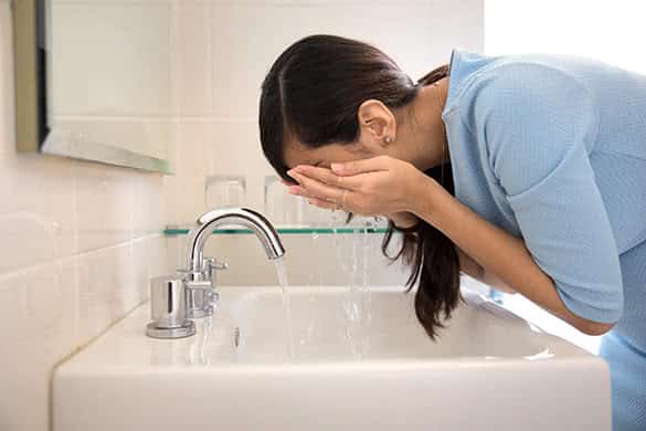 woman washing her face