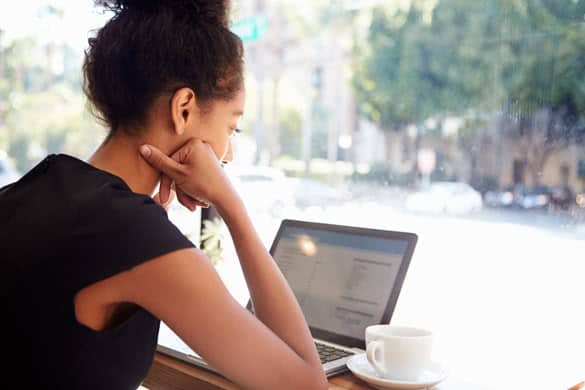 Businesswoman Using Laptop In Coffee Shop