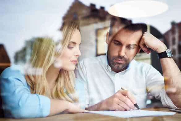 Couple at cafe reading bank contract document