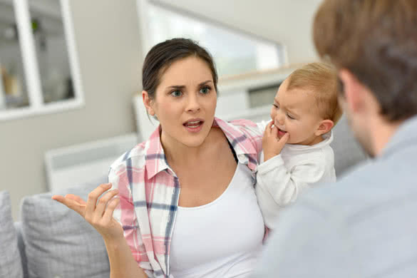 Man and woman arguing in front of baby