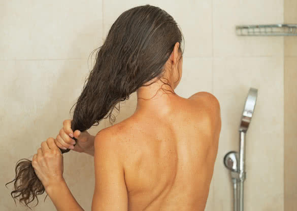 Woman squeezing hair after shower