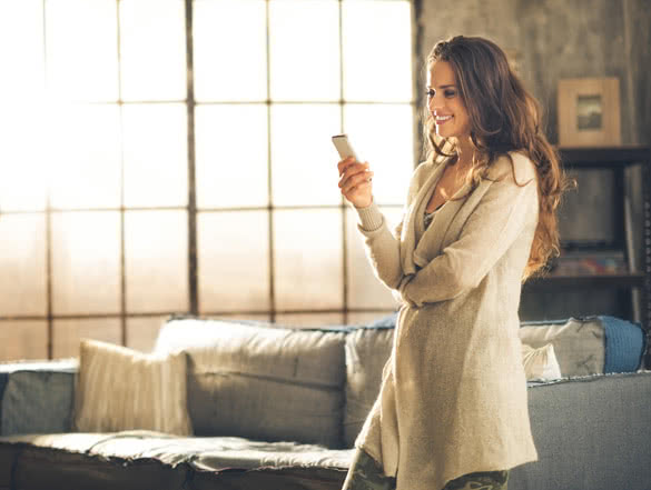 a brunette woman in comfortable clothing is standing in a loft living room