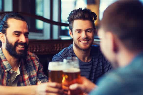 happy male friends drinking beer and clinking glasses at bar or pub