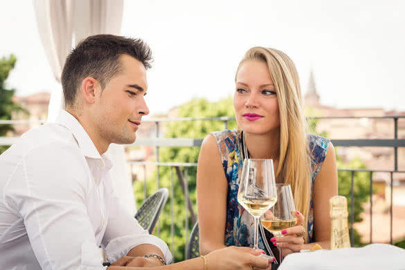 Attractive casual young couple drinking a glass of wine in a hotel terrace