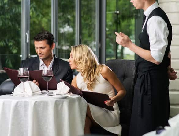 Cheerful couple with menu in a restaurant making order