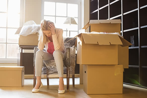 sad woman sitting by the moving boxes