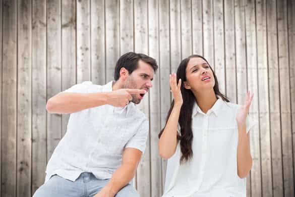 Couple sitting on chairs arguing against wooden planks 2