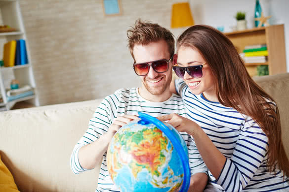 Happy couple with globe choosing place for travel
