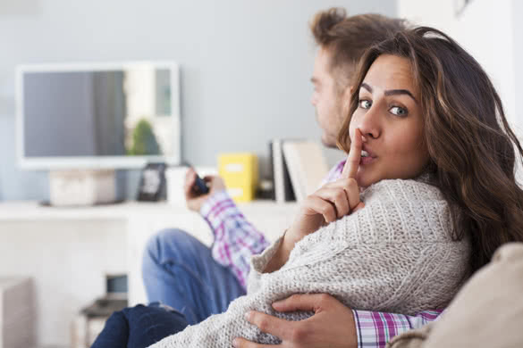 Young couple sitting in the living room watching tv