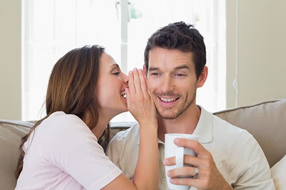 woman whispering in her mans ear