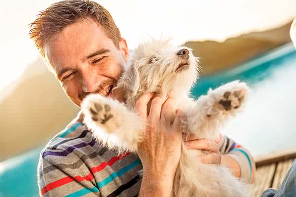 man cuddling a puppy