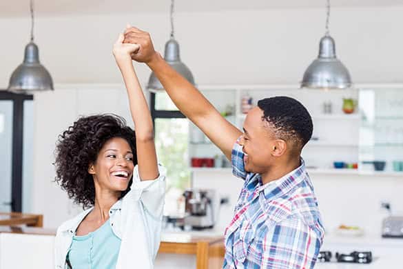 couple dancing in the kitchen and smiling