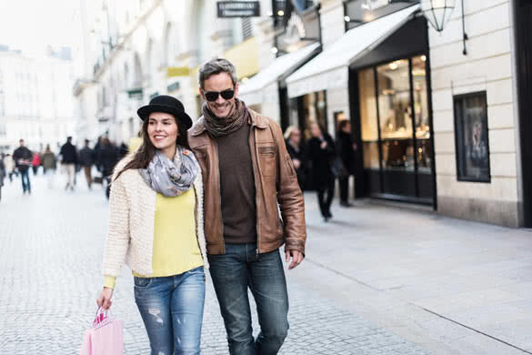 A trendy couple is walking in the city center