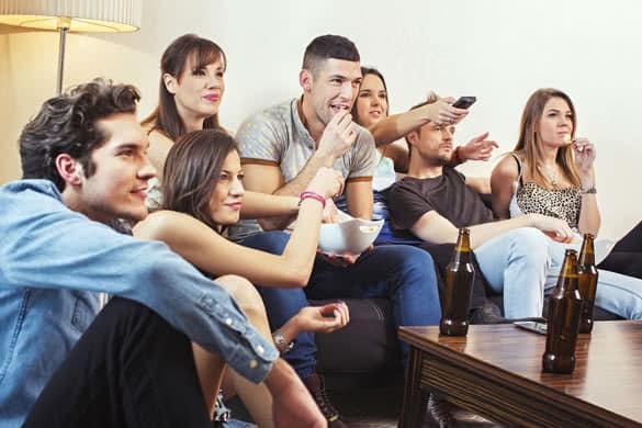 Group of friends watching TV at home