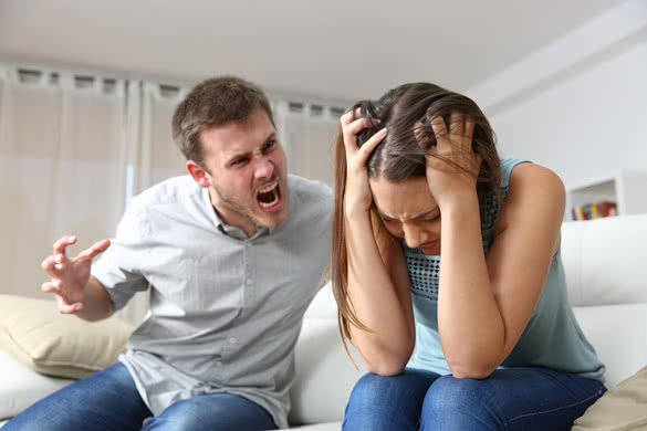 Husband shouting to a scared wife in a house interior